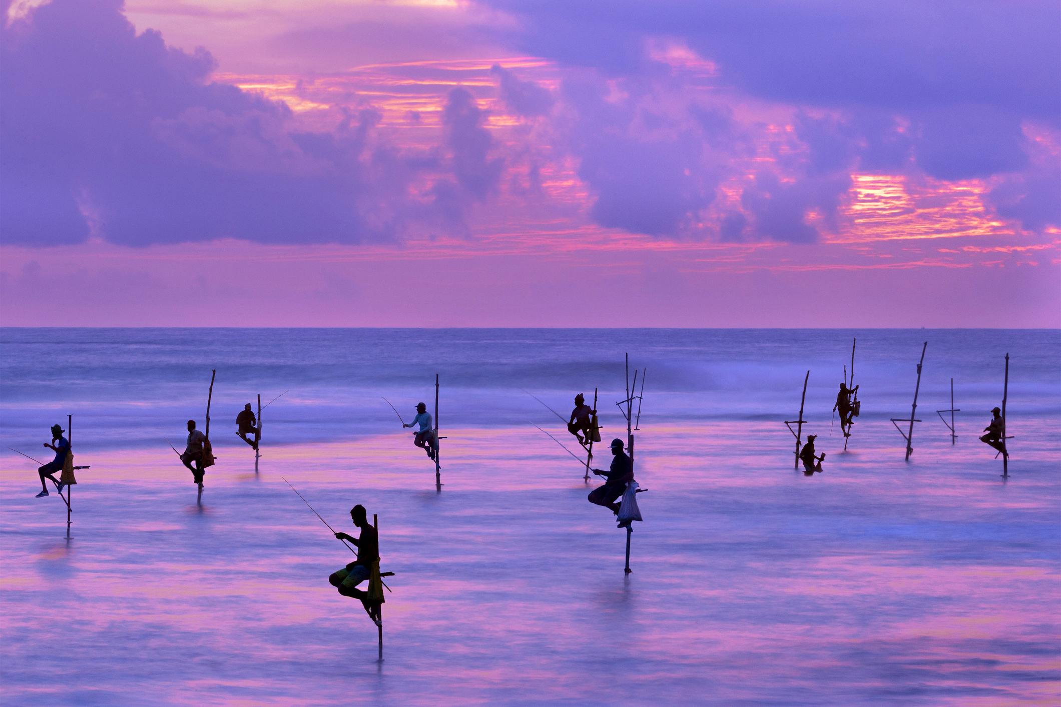 Fishermen on stilts at the sunset, Sri Lanka